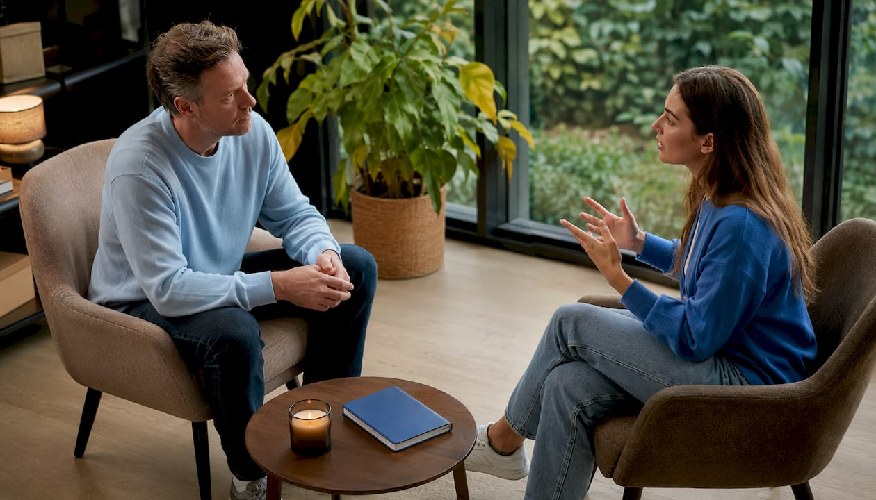 Een coach en een cliënt gaan samen in gesprek over wat zij belangrijk vinden, tijdens een sessie in de praktijkruimte.