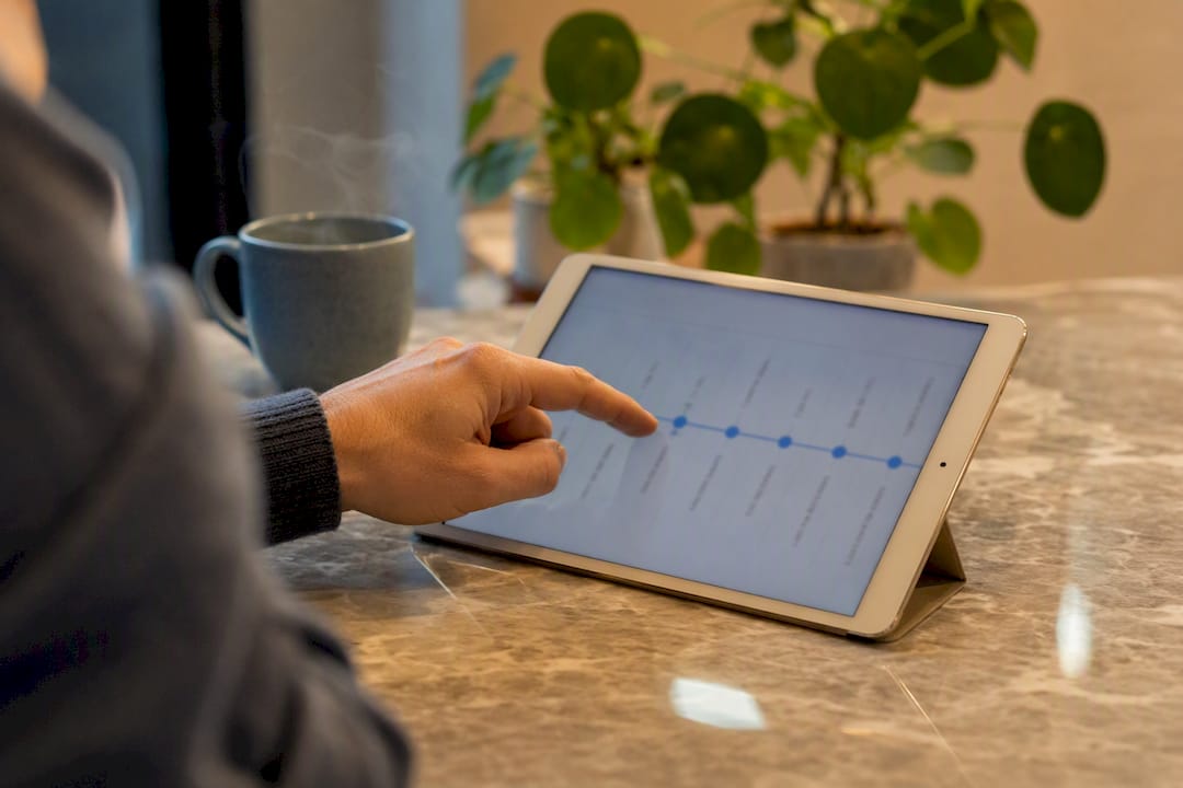 Een hand die op een tablet door de tijdlijn van een klant bladert
