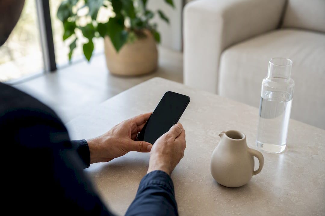 Coach holding a smartphone for client interaction