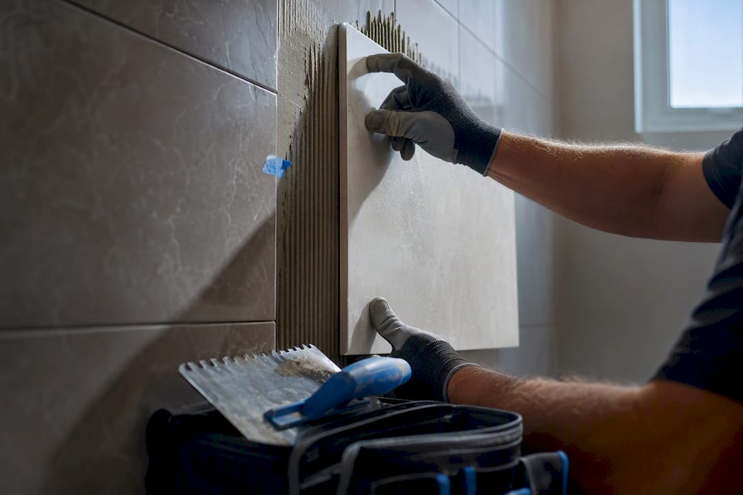 Installer aligning tile over existing bathroom tiles