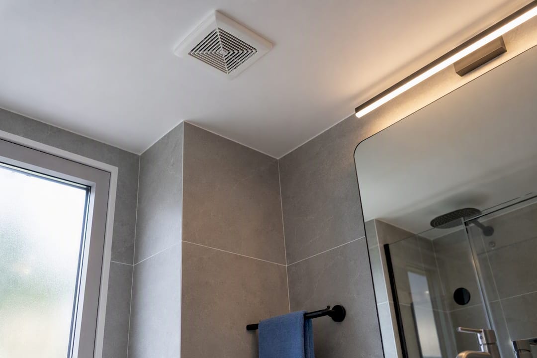 Bathroom extraction vent above clear mirror