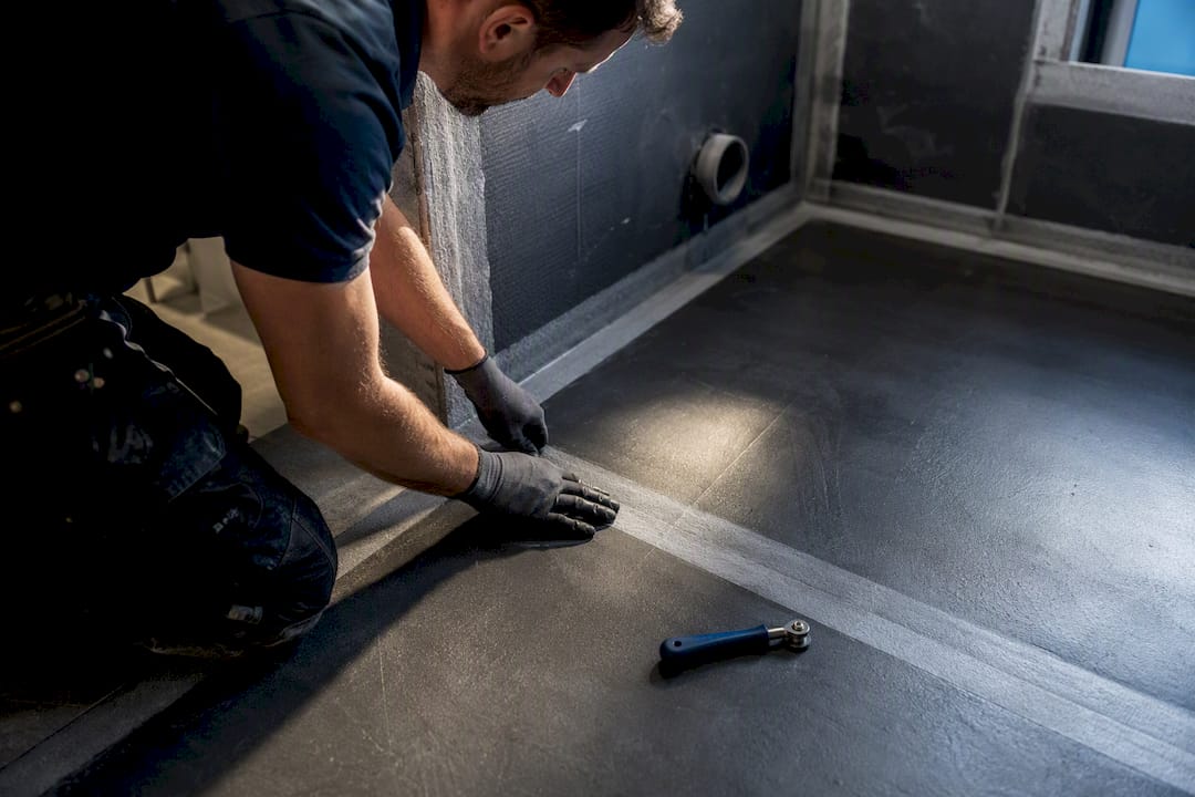 Installer checking wet room tanking corner