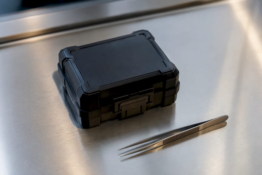 Reference weights and forceps beside protective case