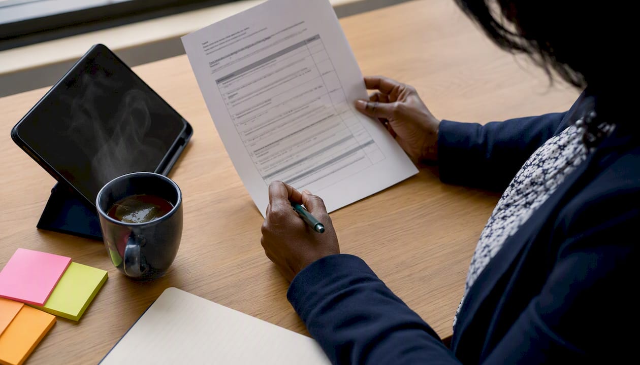 Hands marking AI risk assessment document in meeting