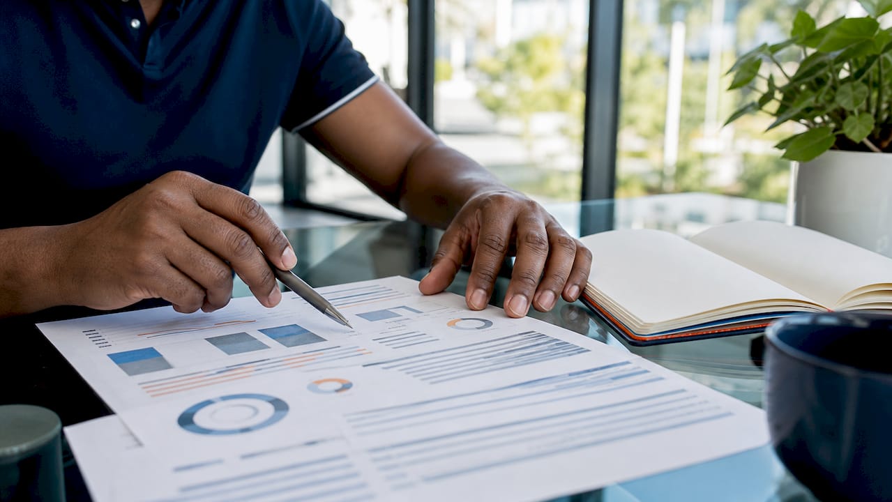 Hands analyzing vendor risk register document