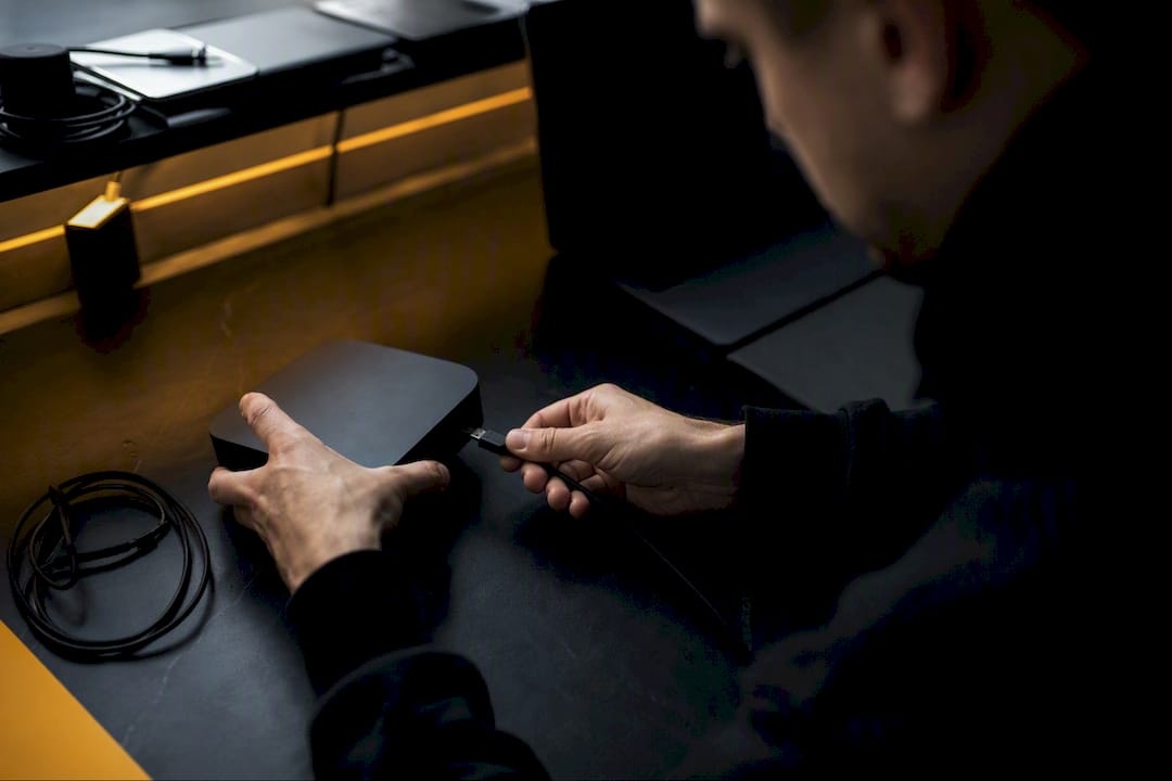 Hands unplugging USB cable at workstation