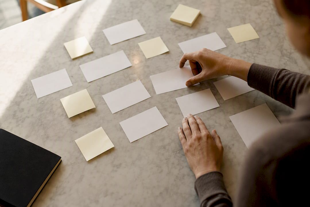 Hands arranging sticky notes for redirect mapping