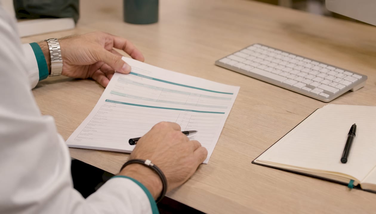 Un profesional revisando cuidadosamente el formato de la cédula en el consultorio.