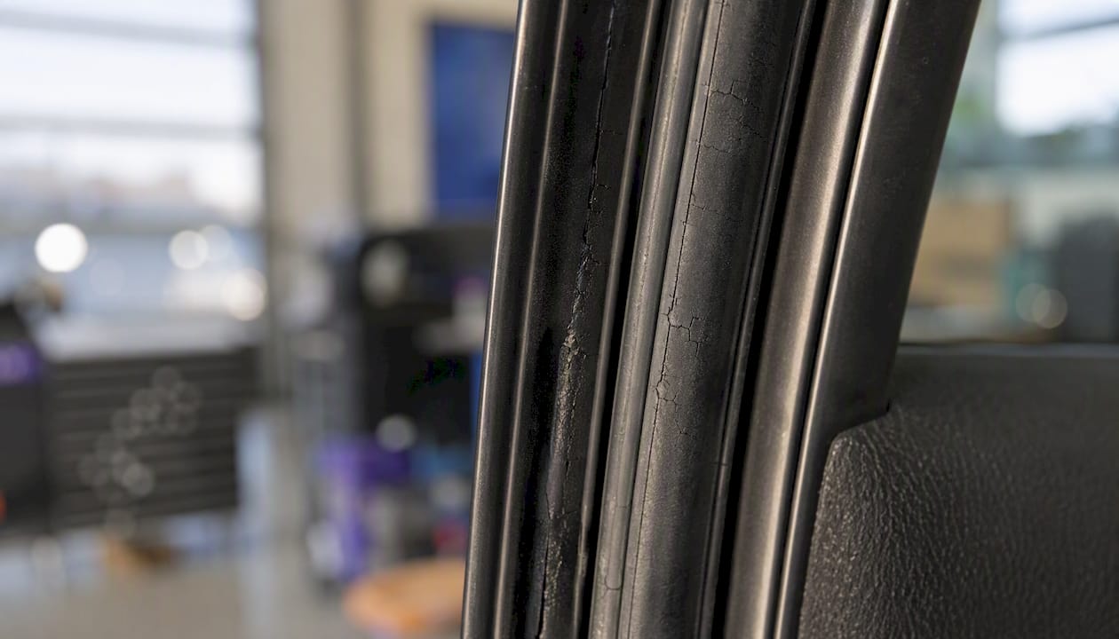 Detailaufnahme einer abgenutzten Gummidichtung an der Autotür