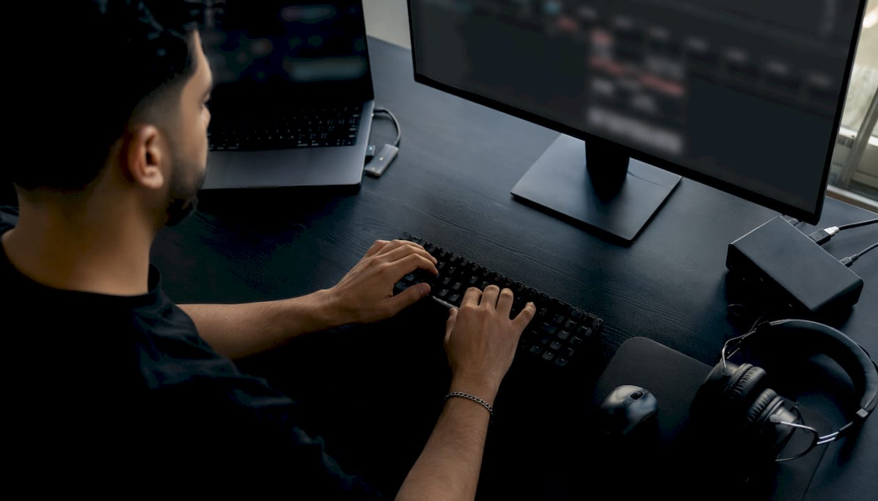 Hands typing at VFX production workstation