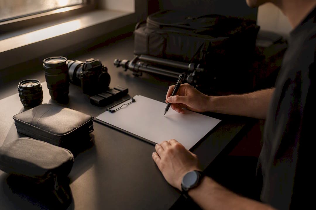 Hands organizing production checklist near camera gear