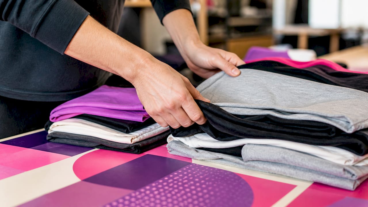 Hands sorting t-shirt sizes for small run