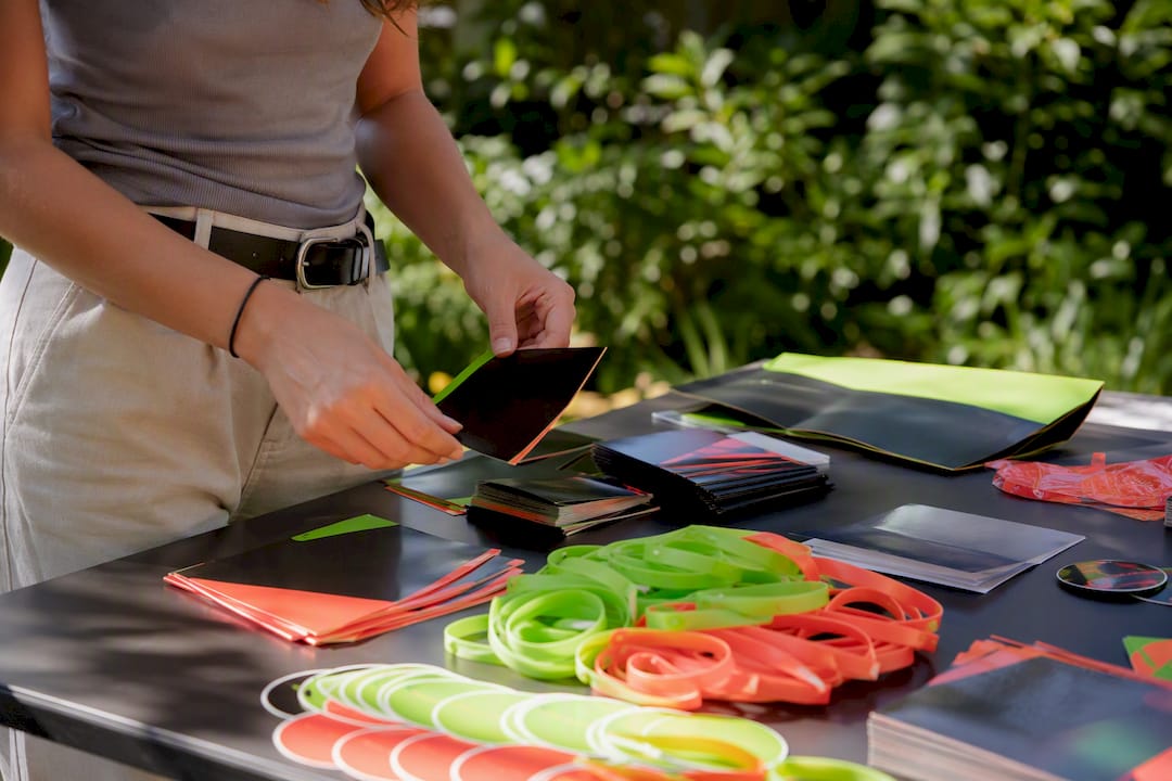 Hands arranging colorful event promotion materials