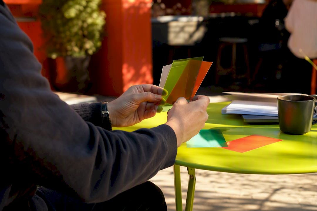 Hands layering colorful translucent cards