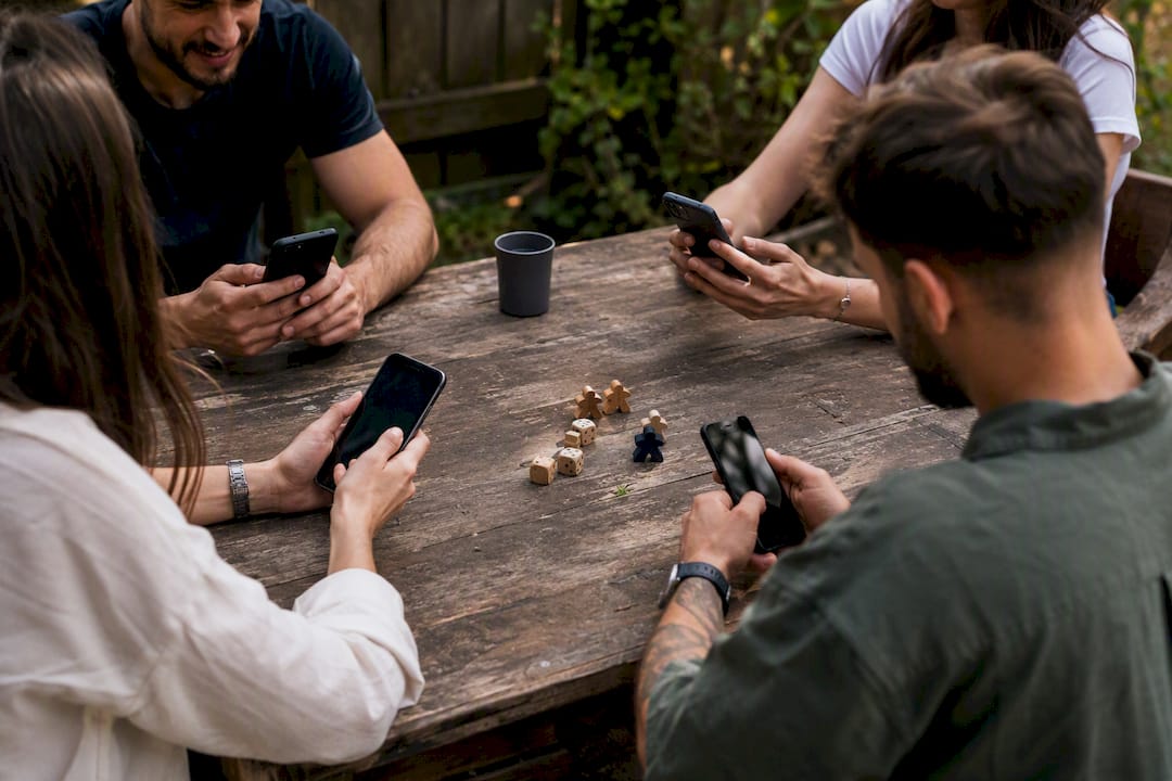 Hände, die Smartphones für ein Partyspiel halten
