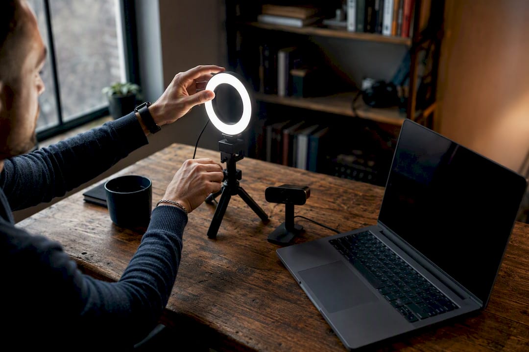 Hands adjusting ring light near webcam