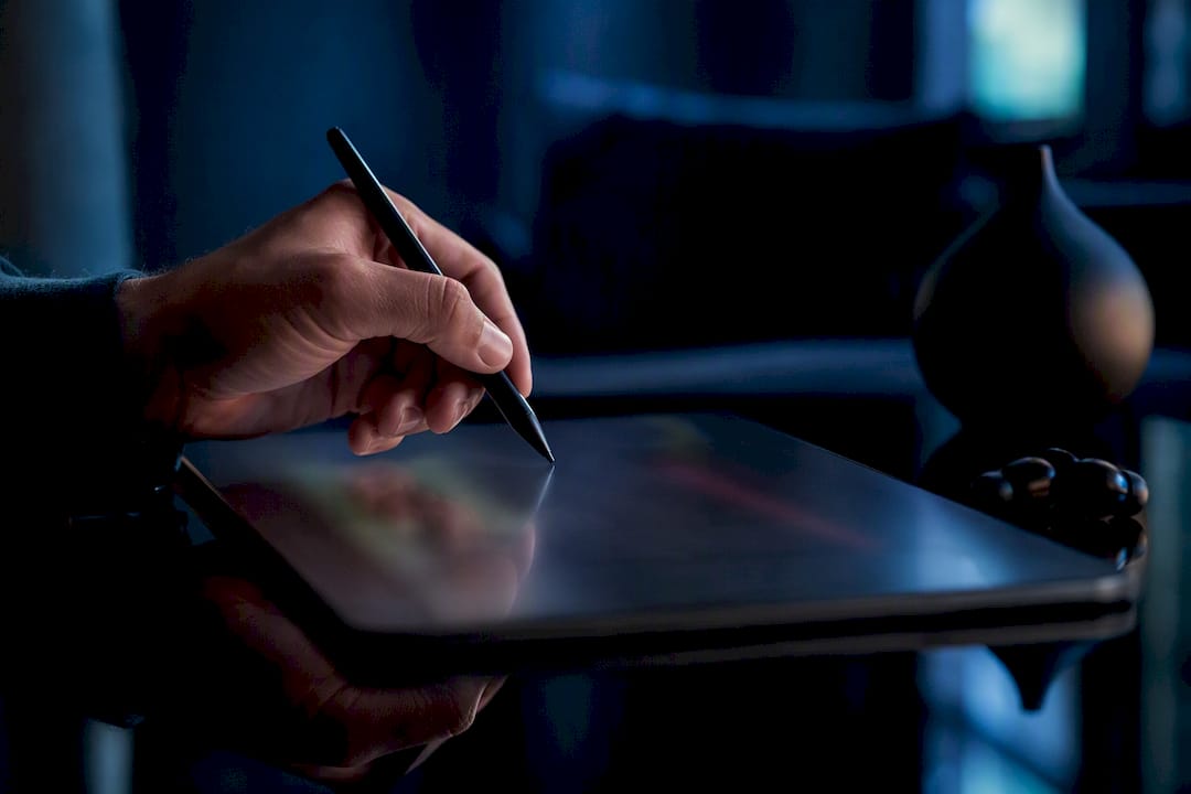 Hand styling captions on tablet in dark studio