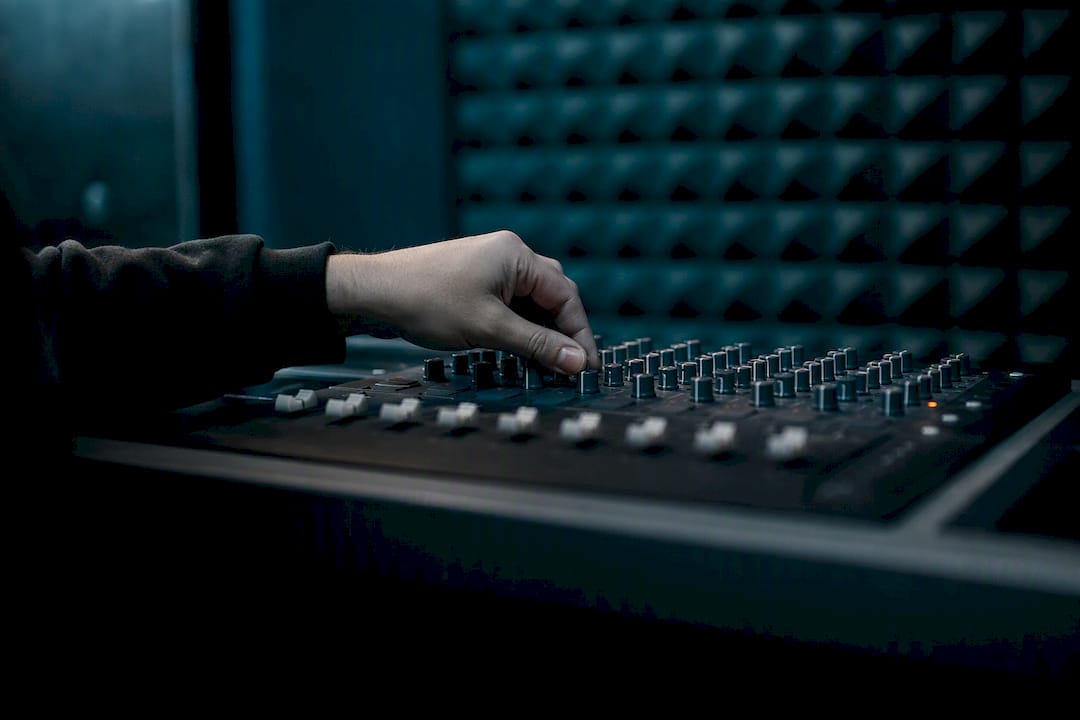 Hand holding headphones on dark desk