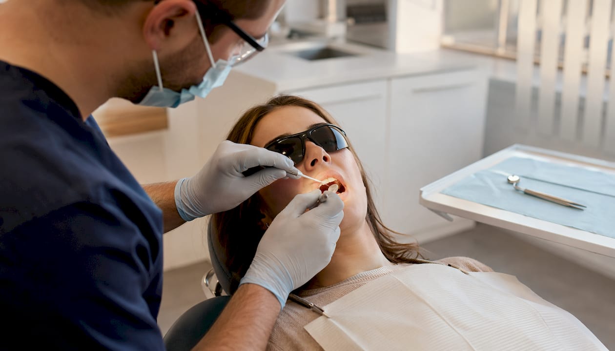 Dentist sculpting composite material on tooth