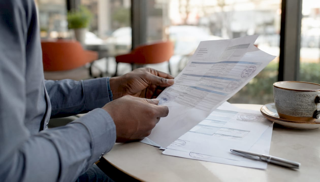 Hands holding financial documents for income verification