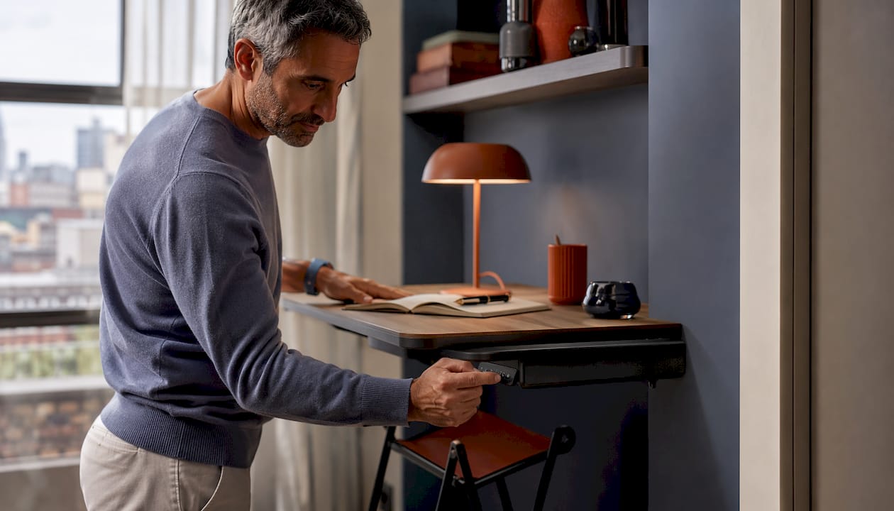 Man adjusting wall-mounted luxury workstation
