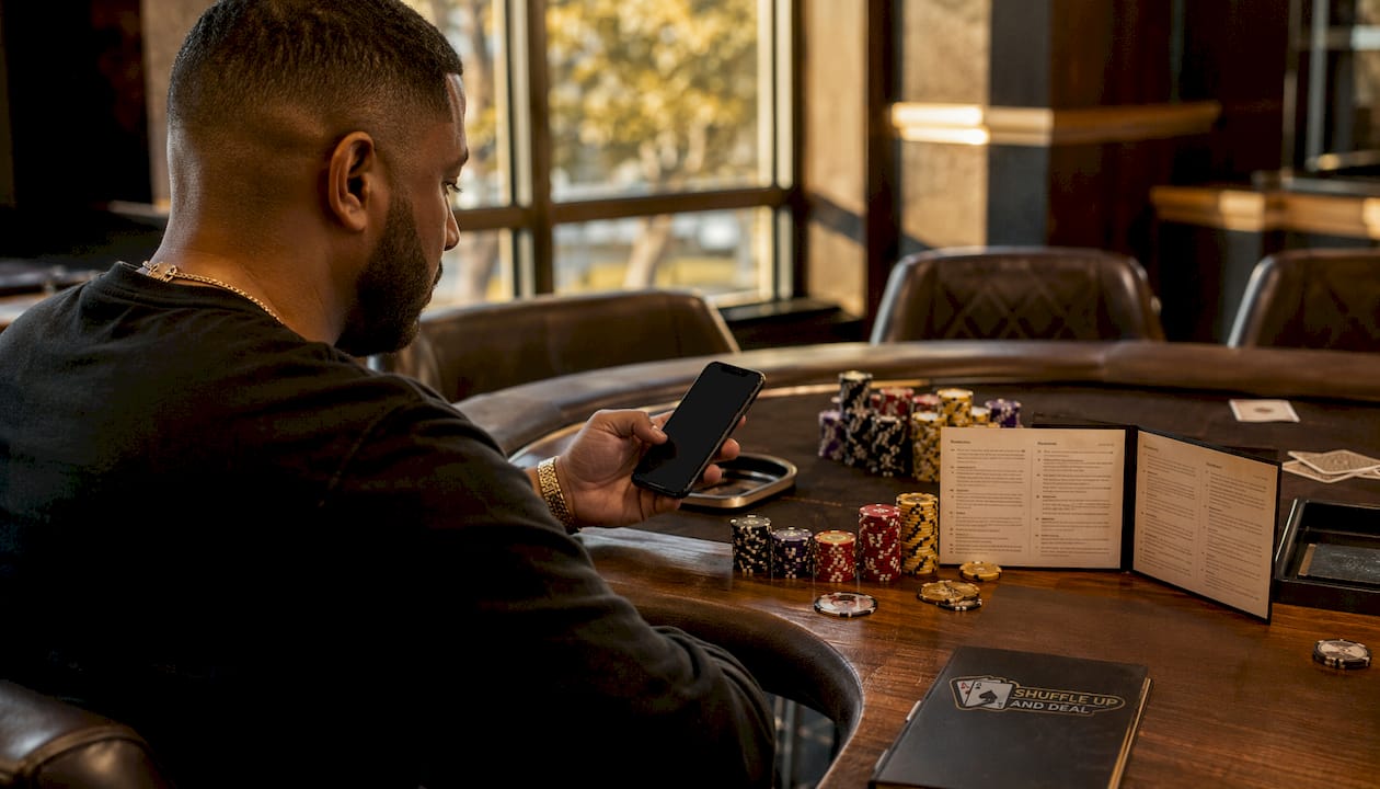 Hands holding phone with poker chips nearby