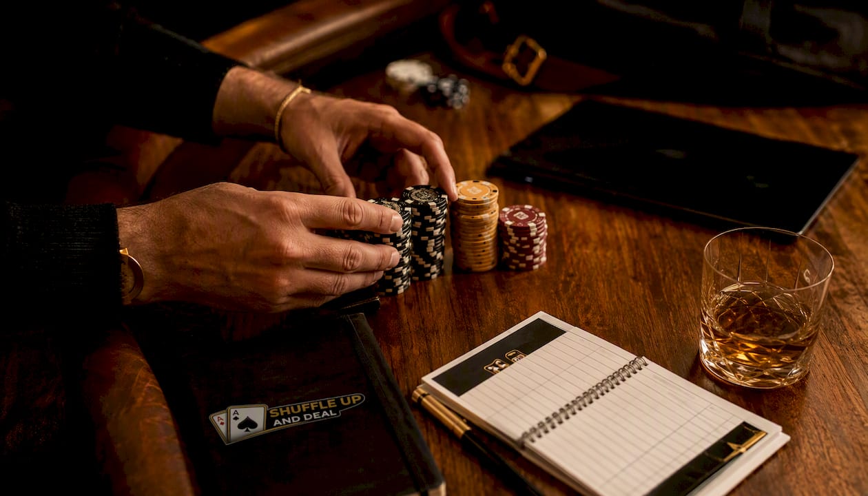 Hands adjusting poker chips by tablet at pub