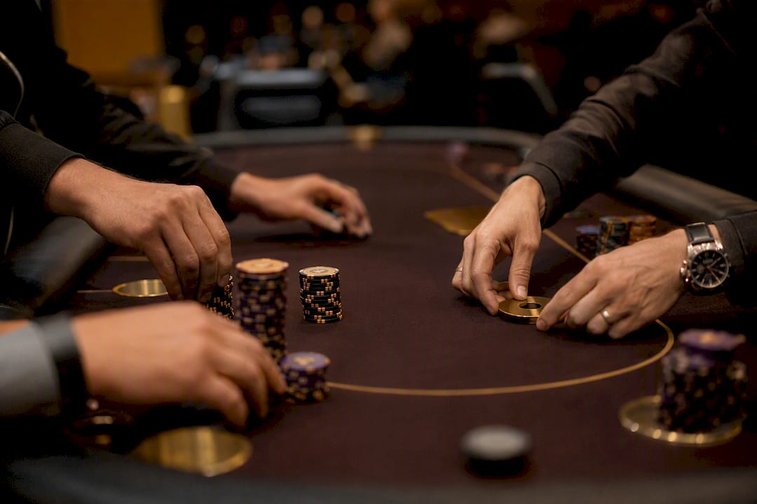 Hands arranging poker chips and seat markers