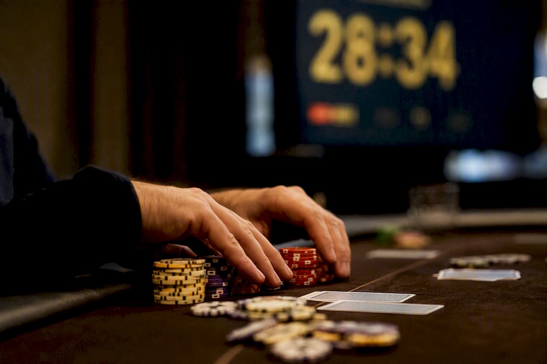 Hands resting on poker chips during bubble delay