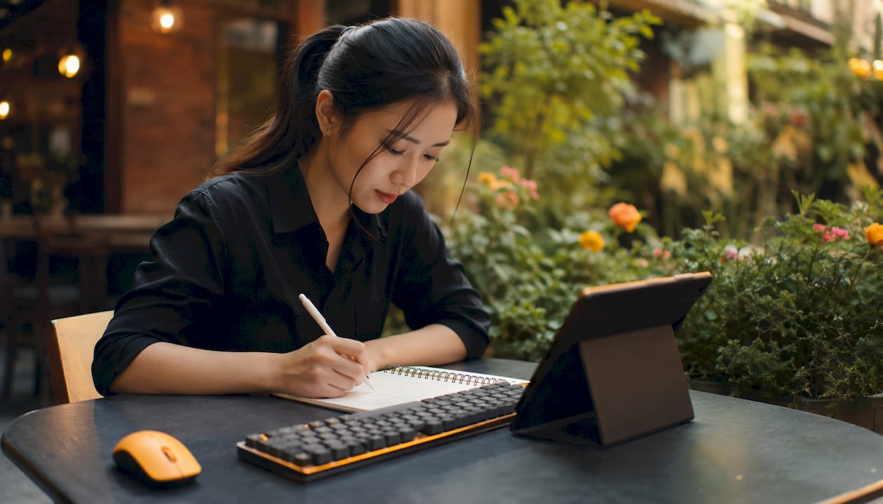 Hands taking notes near performance dashboards