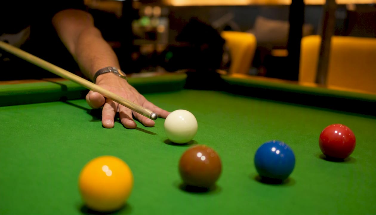 Cue tip striking cue ball on snooker table