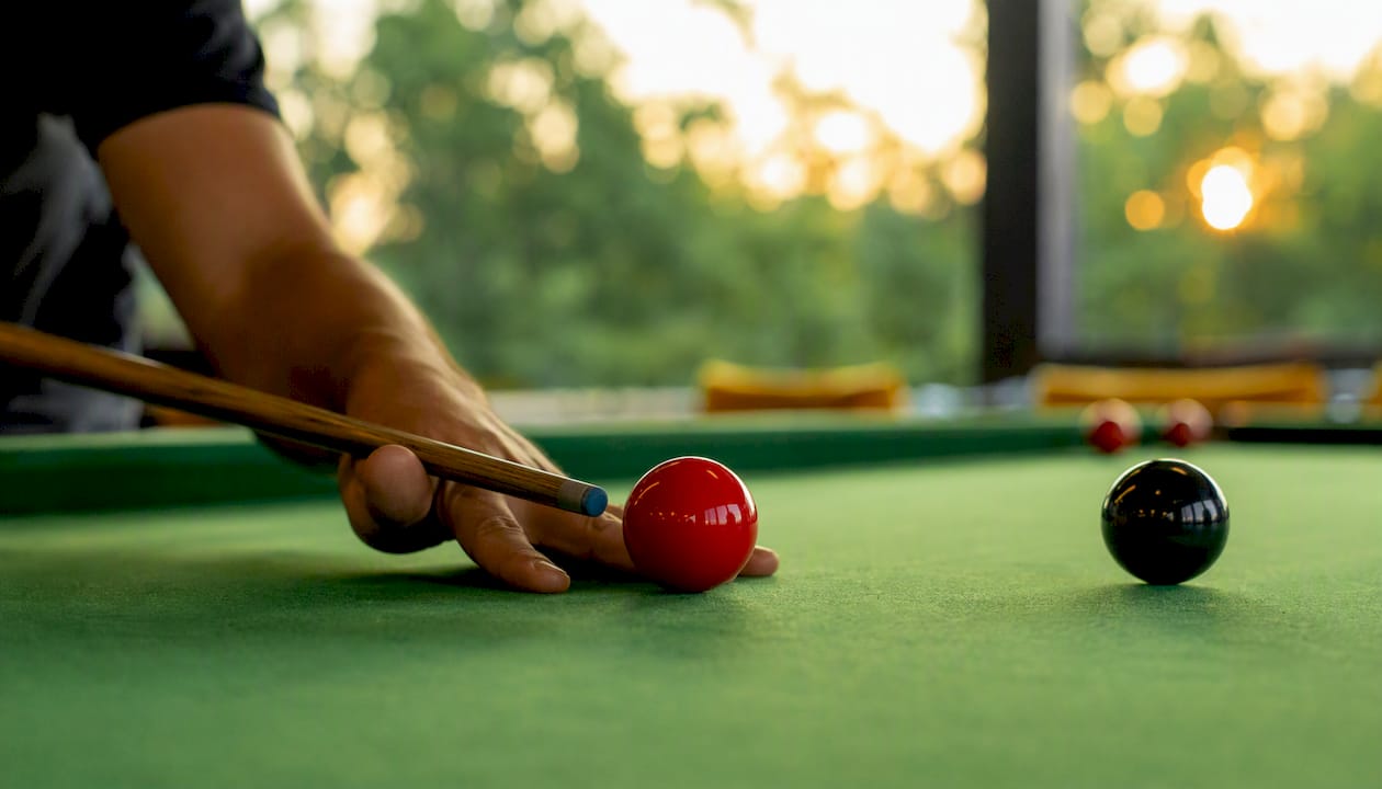 Player potting red then color ball on snooker table