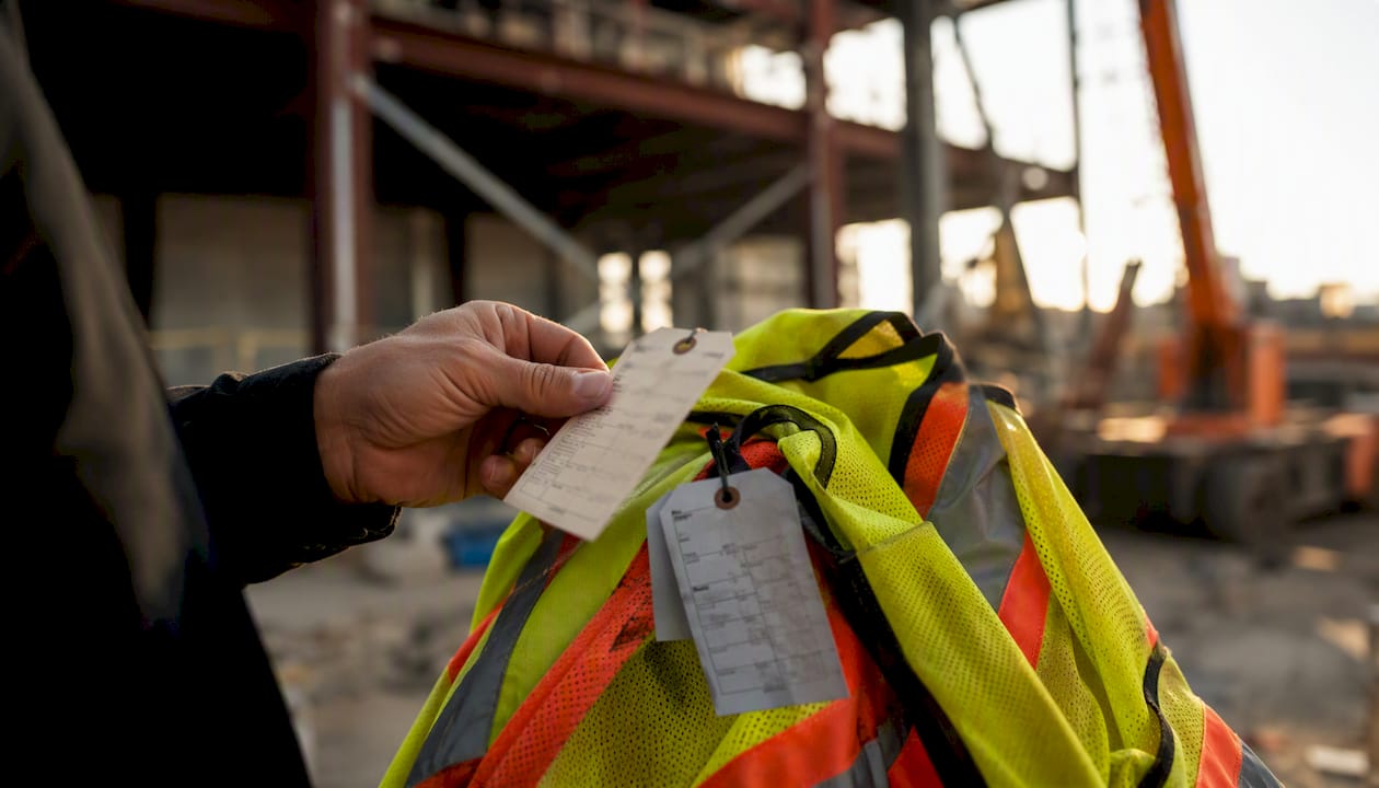 Hand checking safety vest inspection tags