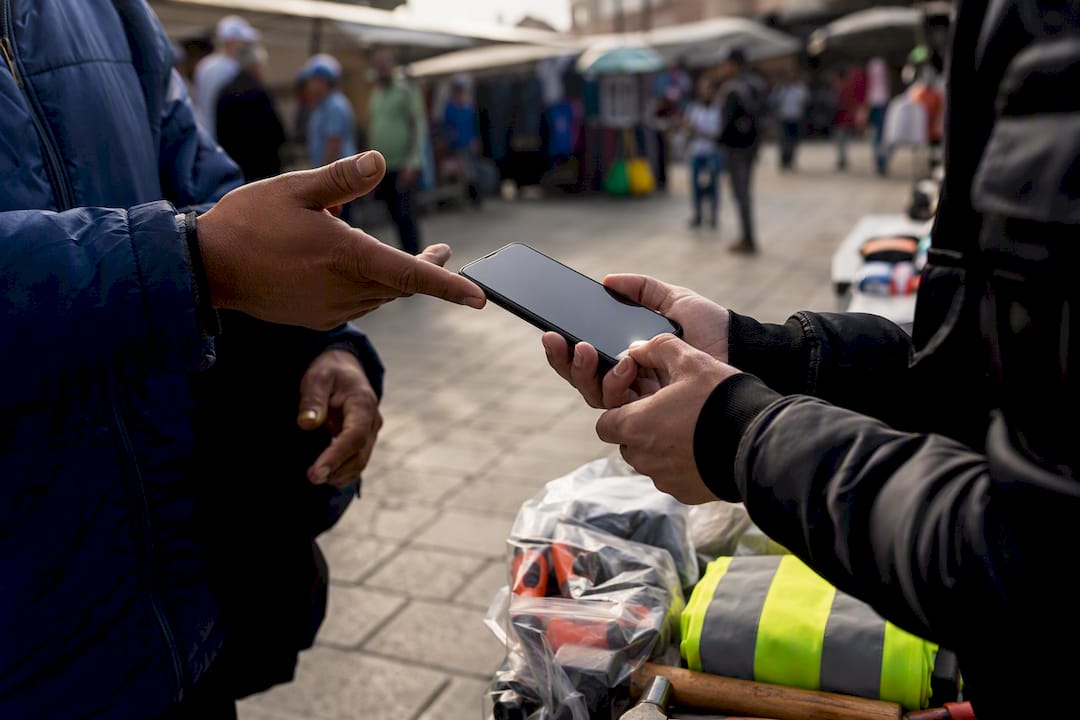 Hands exchanging smartphone at a labor hiring site