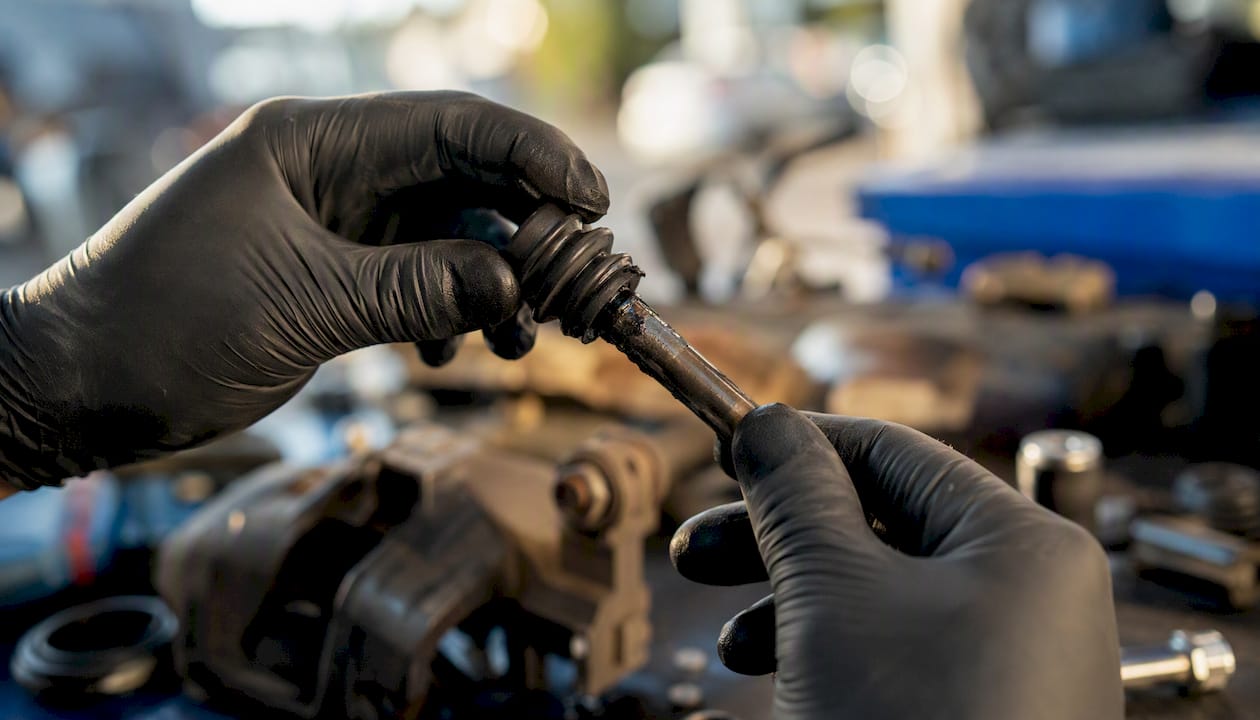 Mechanic inspecting brake slide pin boot