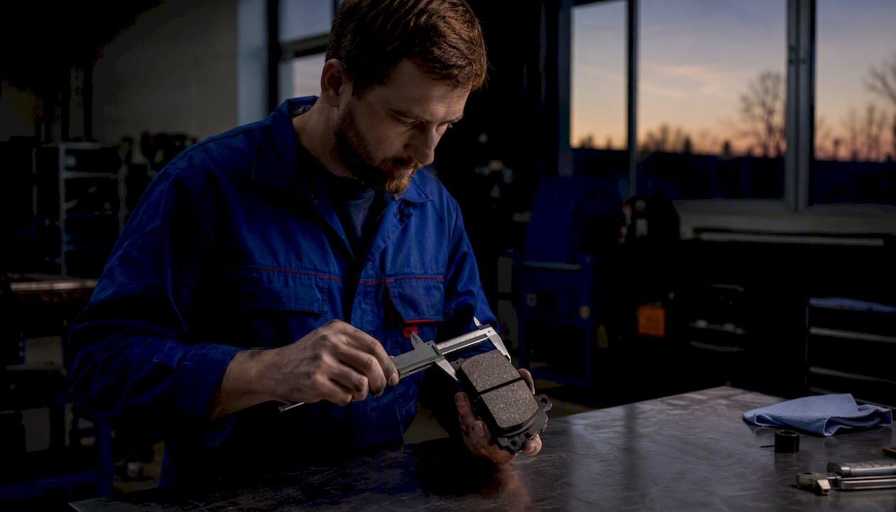 Technician measuring brake pad bevel