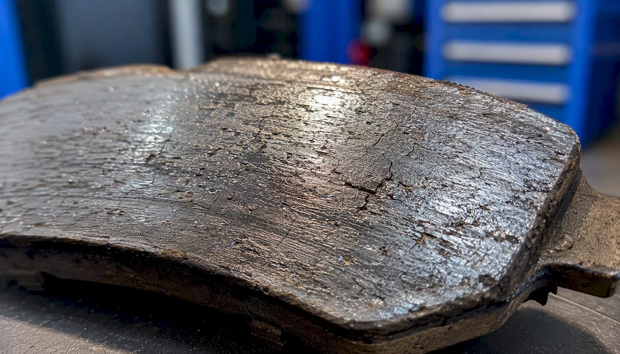 Close-up of glazed shiny brake pad surface