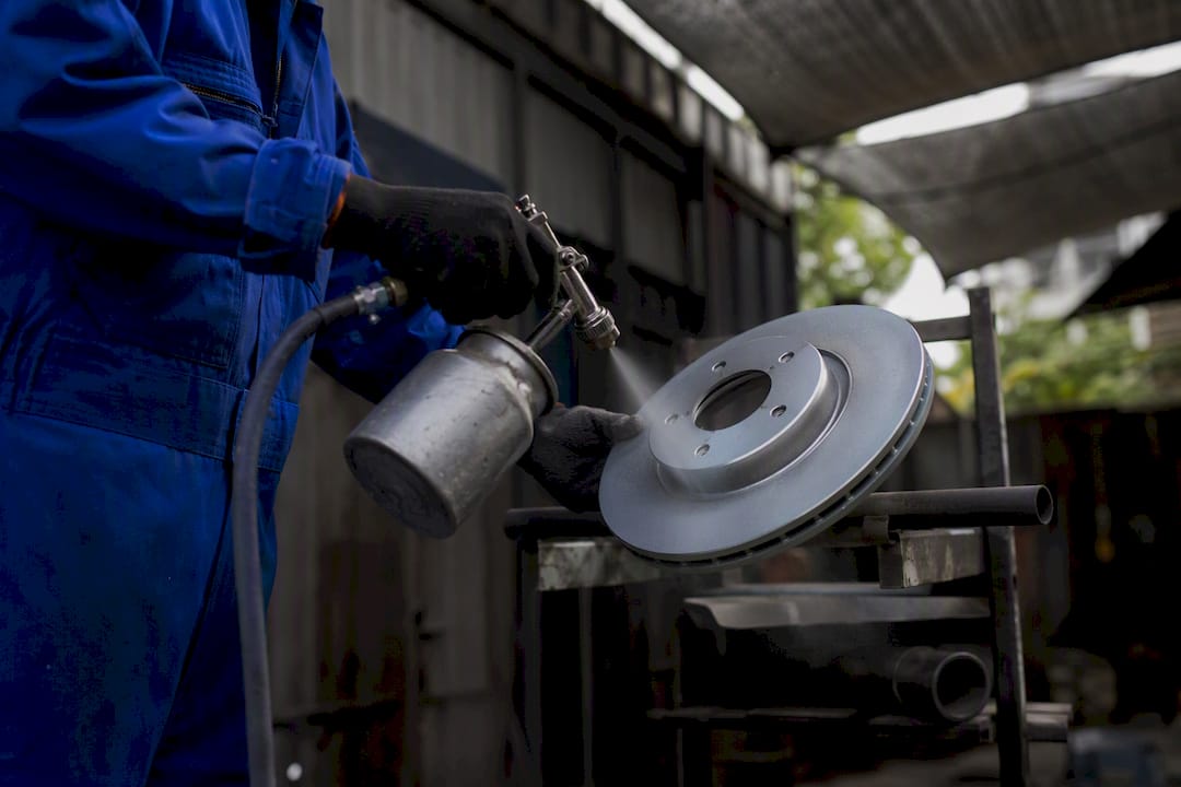 Mechanic applying zinc coating to brake rotor