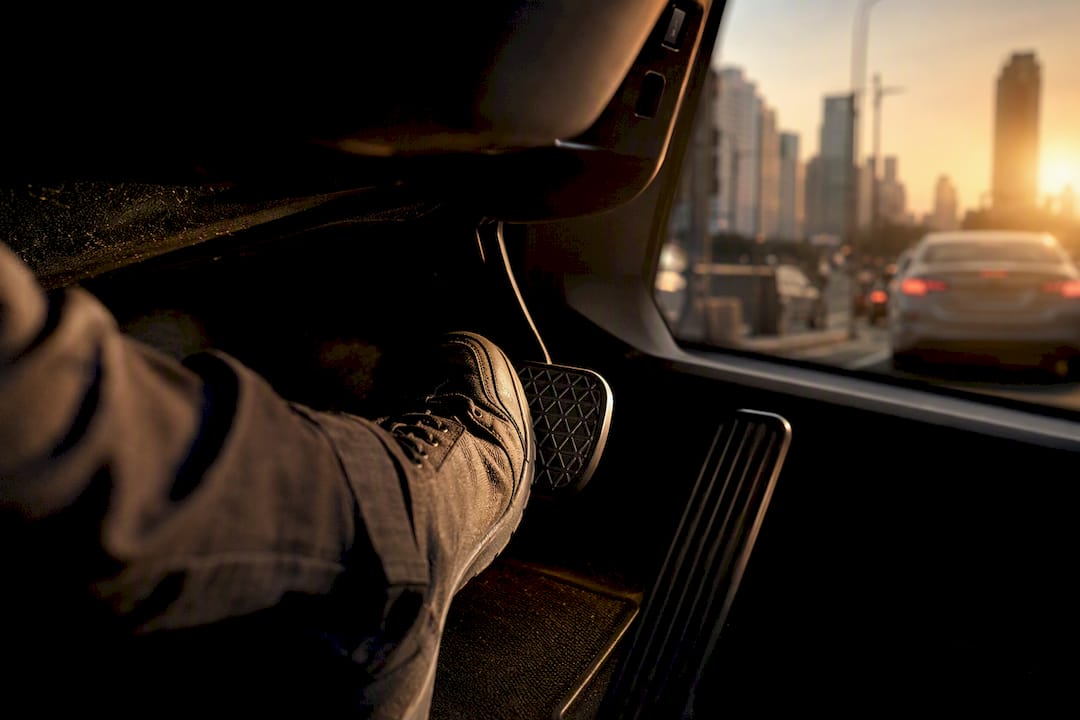 Driver firmly pressing brake pedal during test drive