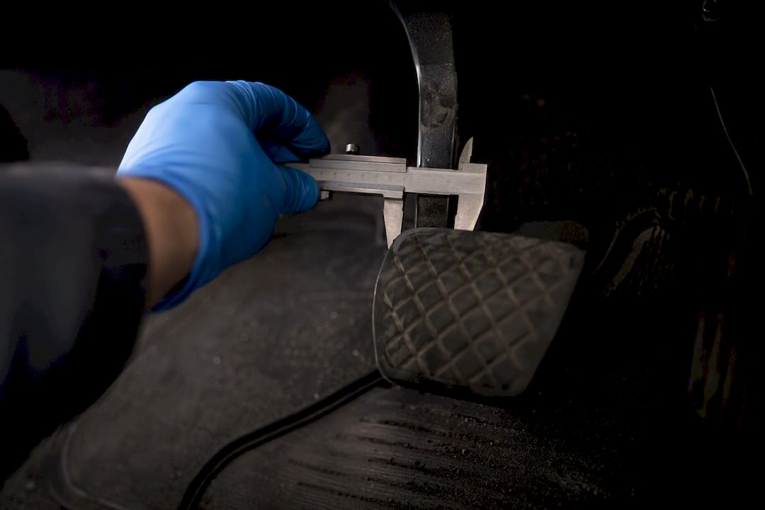 Technician measuring brake pedal travel