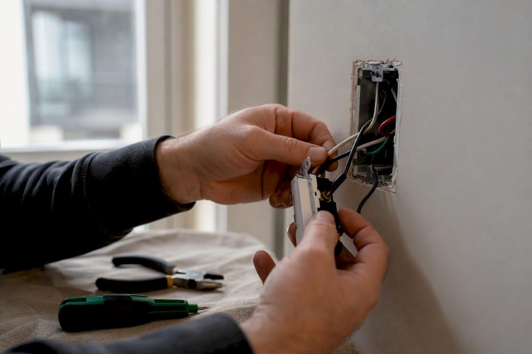 Hands installing LED-compatible dimmer