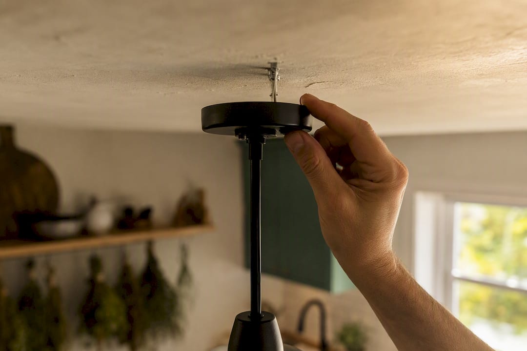 Hand testing drywall anchor for light fixture