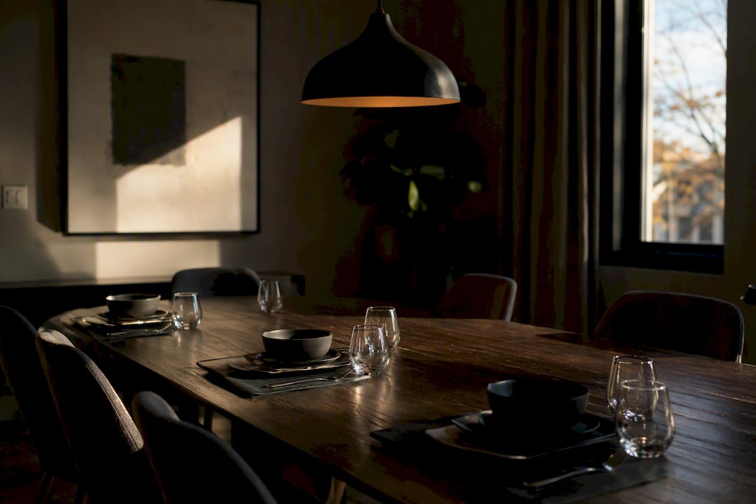 Dining table with uneven lighting from off center pendant