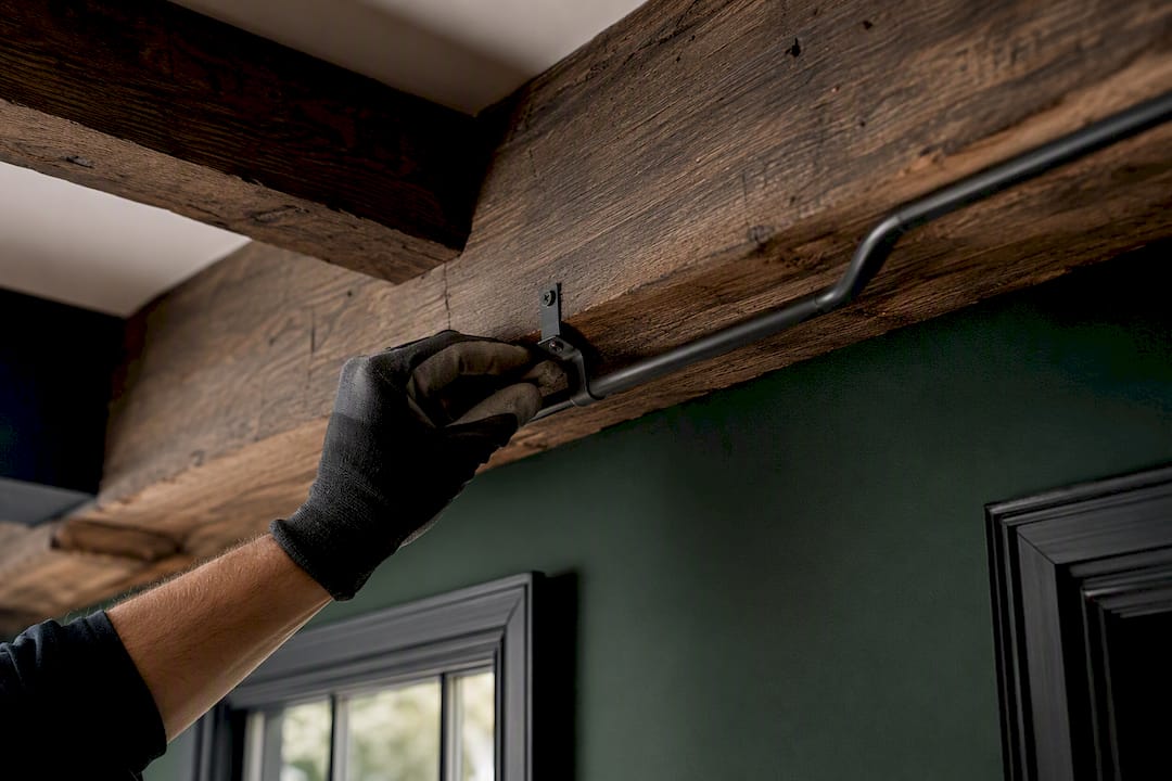 Surface conduit routed along a timber beam