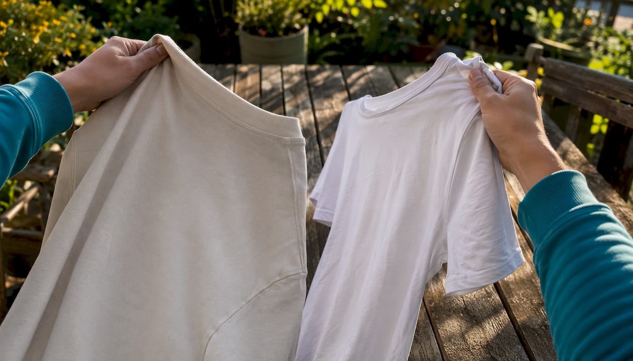 Hands comparing drop shoulder and set-in sleeve t-shirts