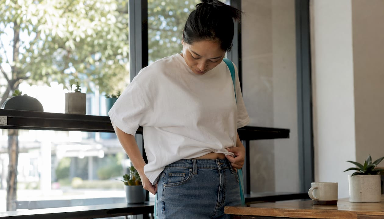 Woman adjusting oversized heavyweight tee indoors