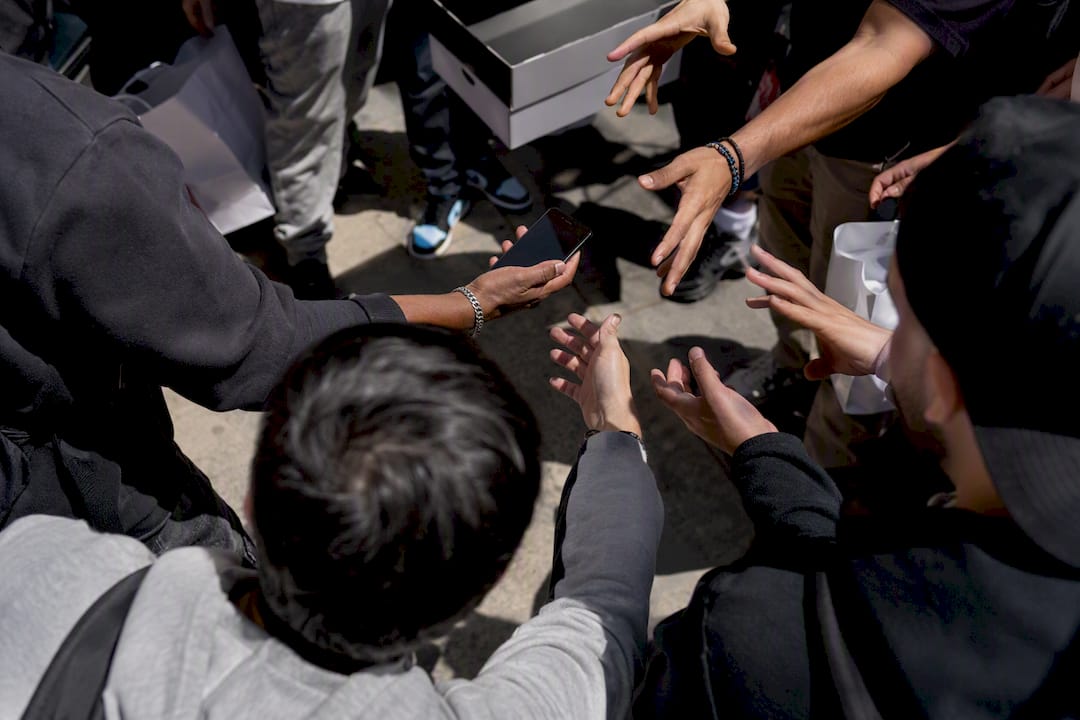Hands reaching at sneaker drop crowd