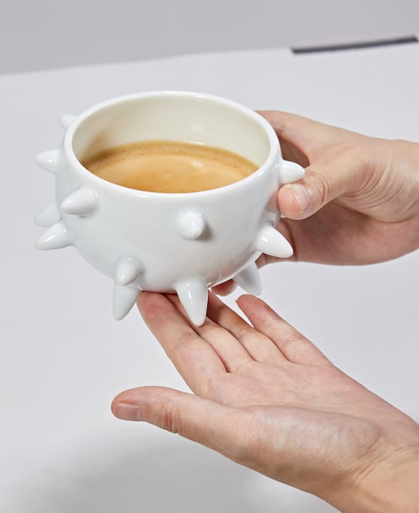 Hand touching porcelain bowl base with glaze detail