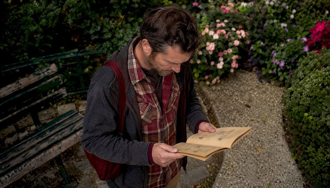 Un homme feuillette un carnet de jeu de piste à Montmartre.