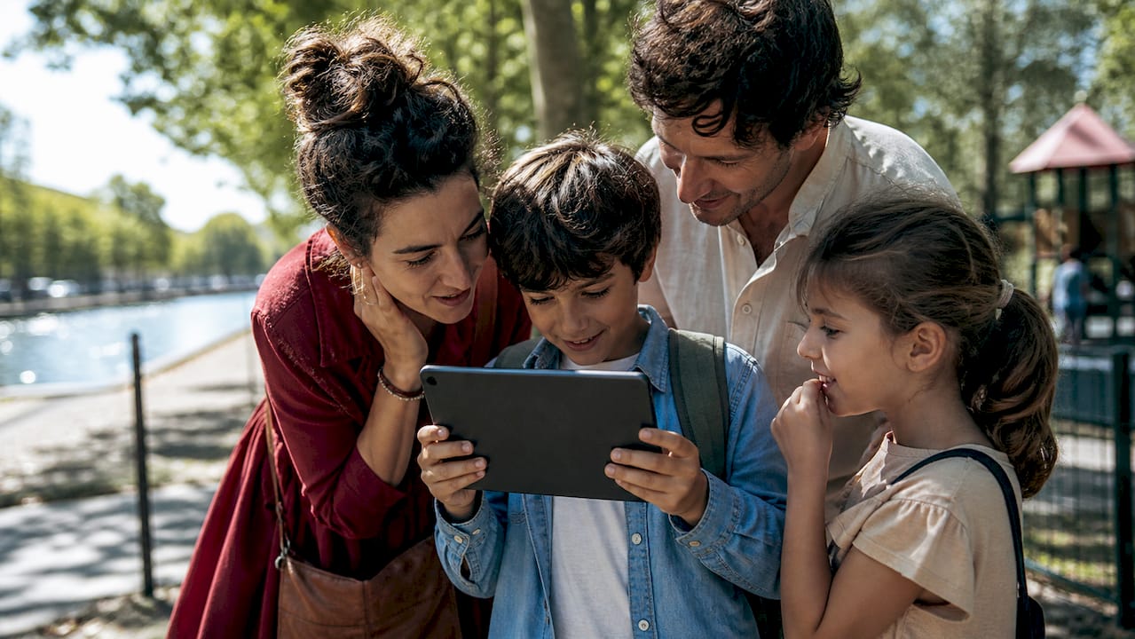 Une famille utilisant un smartphone pour une visite autonome du parc